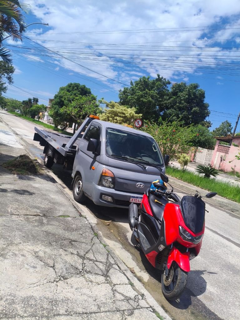 Motocicleta vermelha ao lado do caminhão de guincho da TS Transportes