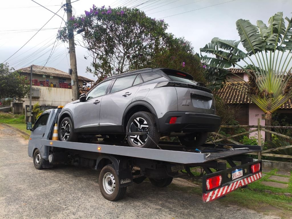 Veículo cuidadosamente fixado à plataforma para transporte